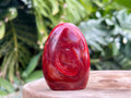 Carnelian freeform with rich orange and red swirls, polished to a glossy finish, radiating warmth, vitality, and creative energy
