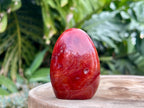 Carnelian freeform with rich orange and red swirls, polished to a glossy finish, radiating warmth, vitality, and creative energy