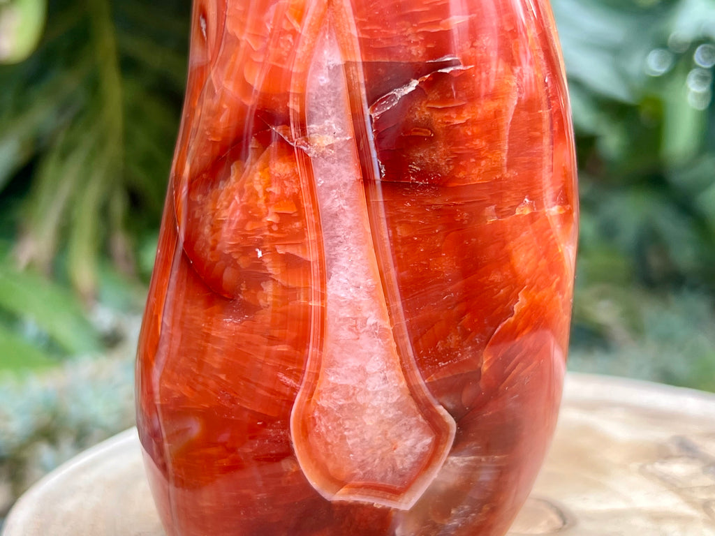 Carnelian freeform with rich orange and red swirls, polished to a glossy finish, radiating warmth, vitality, and creative energy