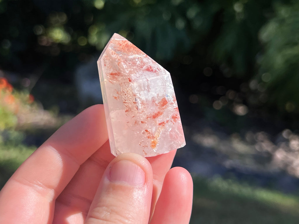 Hematoid Quartz point with clear and reddish-golden inclusions, combining the grounding energy of Hematite with the clarity of Quartz. This photo i have the point in my hand for a size guide 