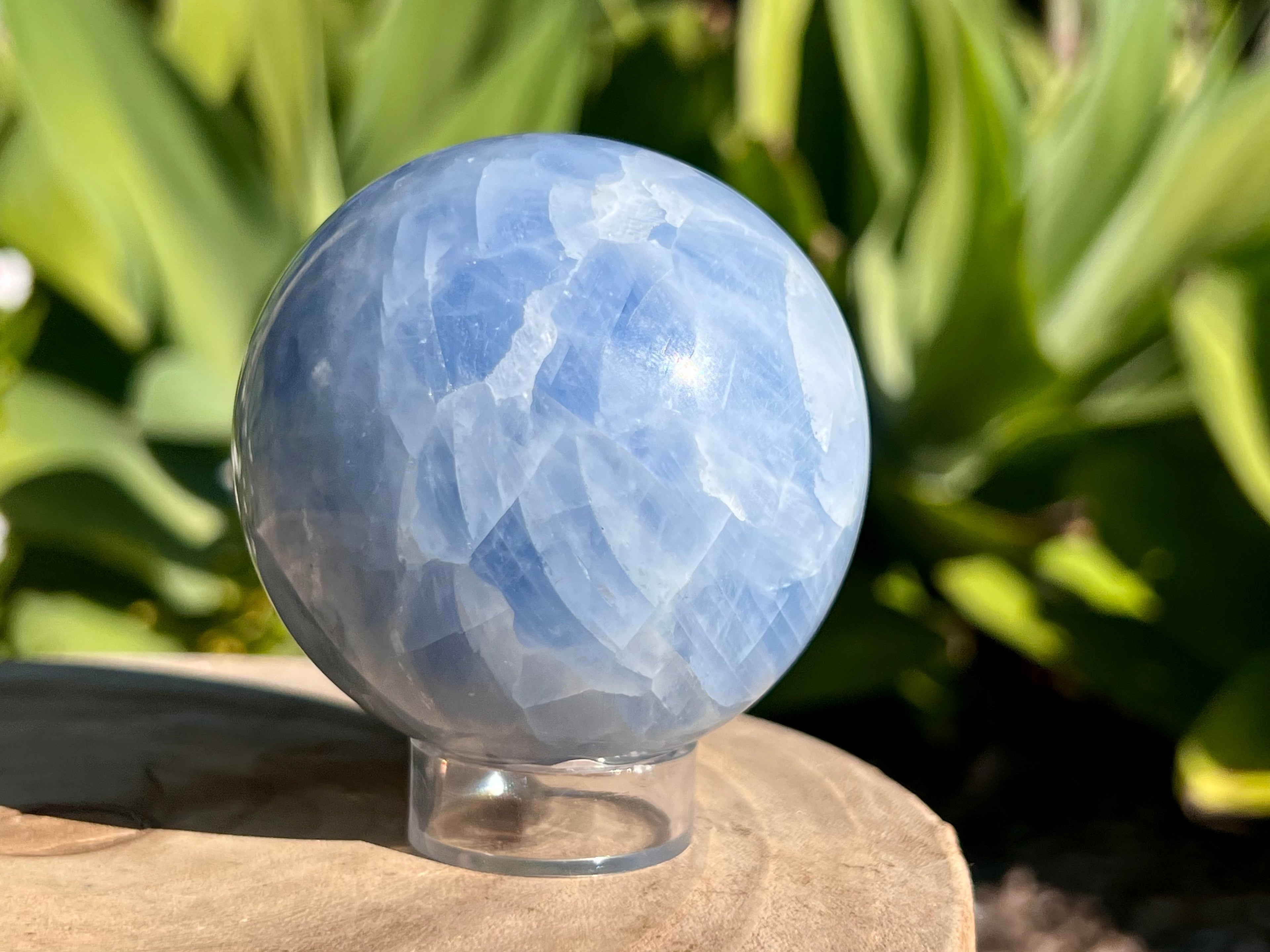 Smooth Blue Calcite sphere with soft, calming blue hues and natural marbling, used for soothing energy and enhancing communication