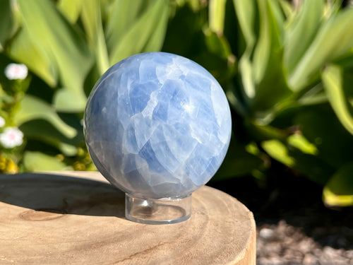 Smooth Blue Calcite sphere with soft, calming blue hues and natural marbling, used for soothing energy and enhancing communication