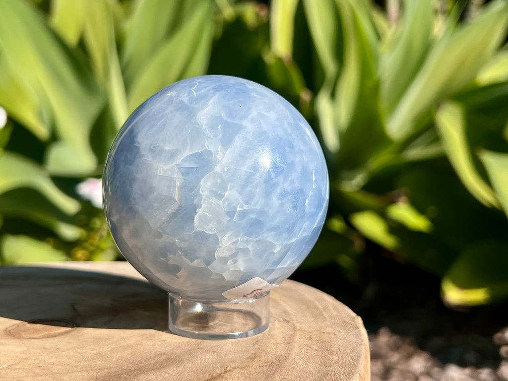 Smooth Blue Calcite sphere with soft, calming blue hues and natural marbling, used for soothing energy and enhancing communication