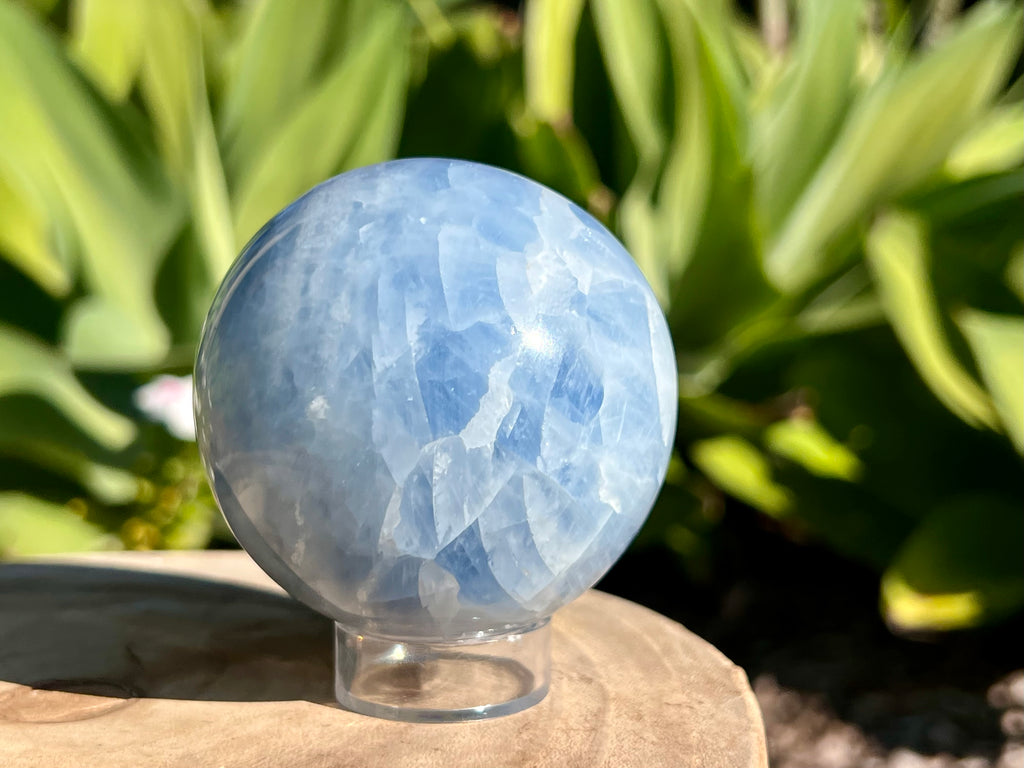 Stunning blue calcite sphere on a plastic sphere stand 