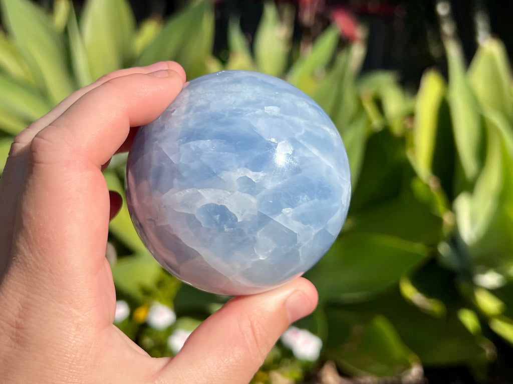 Blue Calcite sphere in my hand for a size guide 