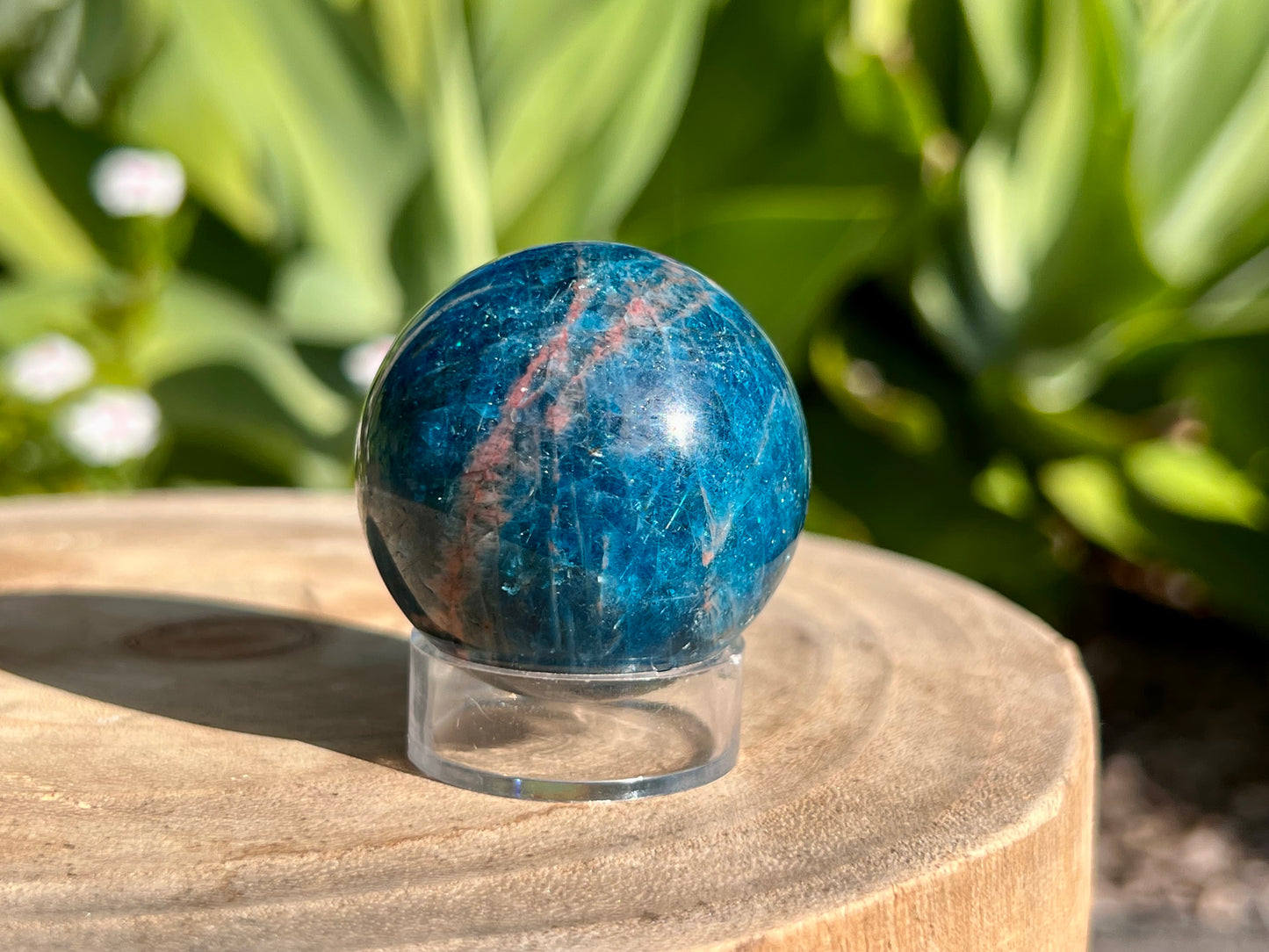Apatite sphere with a beautiful red line through it. On a sphere stand 