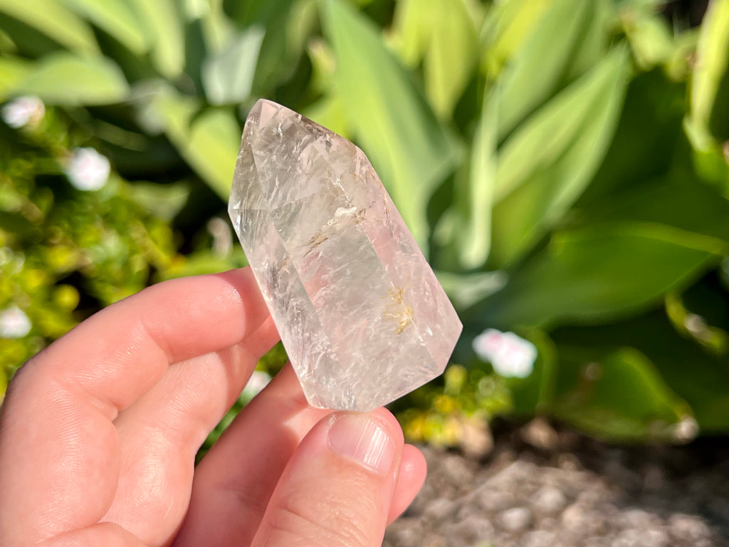 Clear quartz point in my hand for size guide 